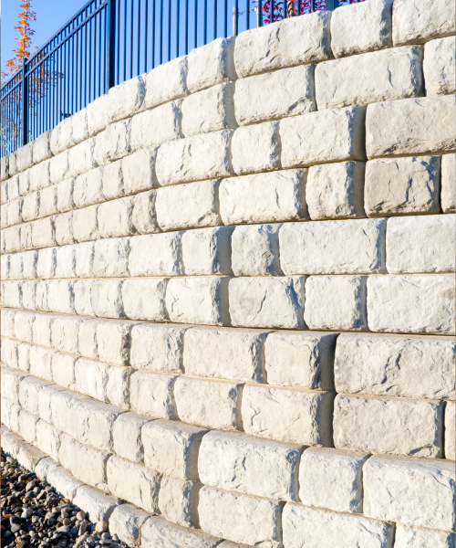 A close up of a brick wall with a fence in the background